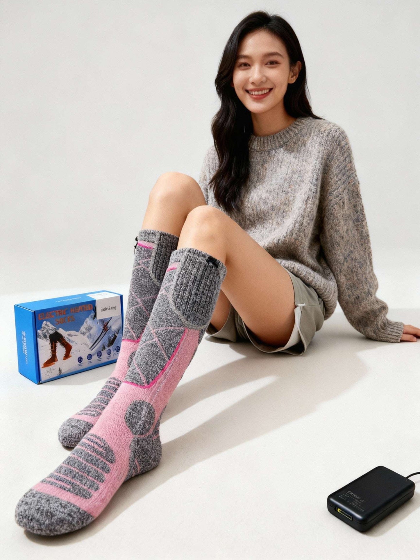 Woman wearing washable, battery-powered heated socks with 4000 mAh rechargeable battery and USB charging for winter warmth and comfort